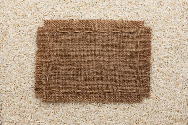 Frame made of burlap with the line lies on  rice  grains — Stock Photo, Image