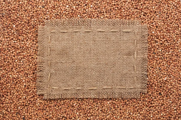 Frame made of burlap with the line lies on  buckwheat  grains — Stock Photo, Image