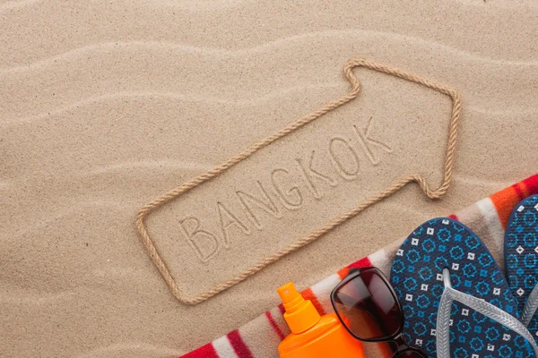 Bangkok  pointer and beach accessories lying on the sand — Stock Photo, Image