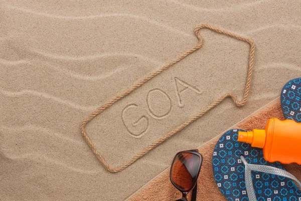 Goa pointer and beach accessories lying on the sand — Stock Photo, Image