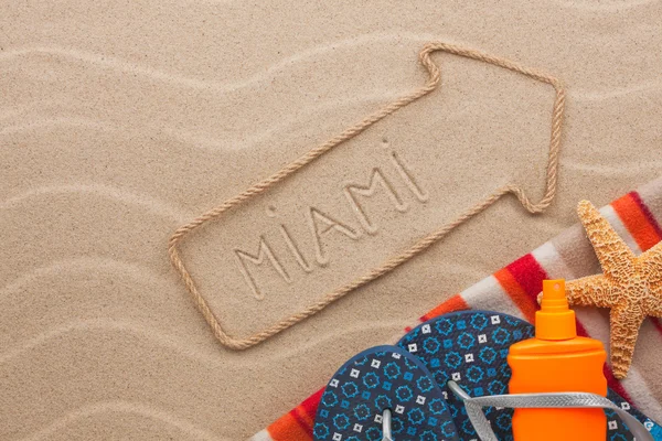 Miami pointer and beach accessories lying on the sand — Stock Photo, Image