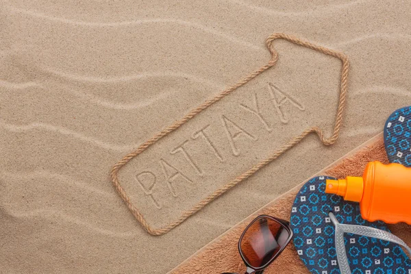 Pattaya  pointer and beach accessories lying on the sand — Stock Photo, Image