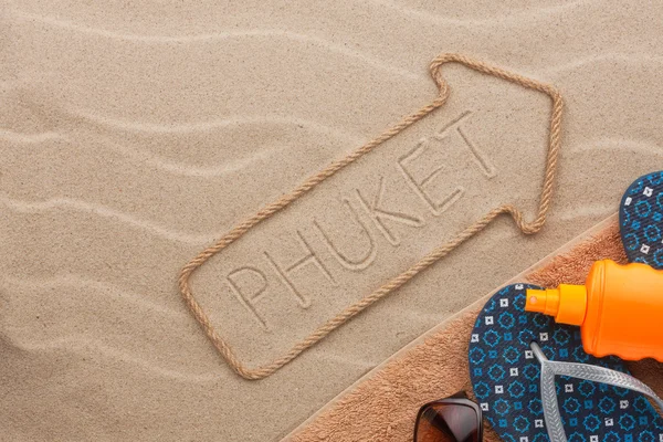 Phuket  pointer and beach accessories lying on the sand — Stock Photo, Image