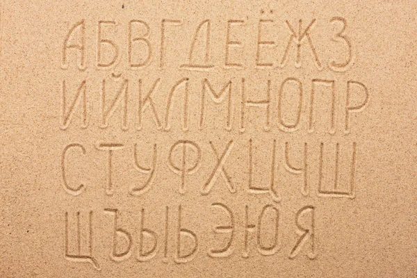 Rus alfabesi kum üzerine yazılmış