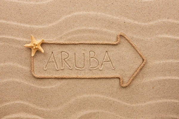 Arrow made of rope and sea shells with the word Aruba on the san — Stock Photo, Image