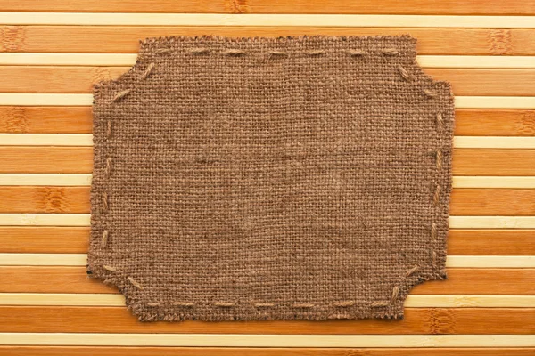 Rahmen aus Klette, liegt auf einem Hintergrund aus Bambusmatte — Stockfoto