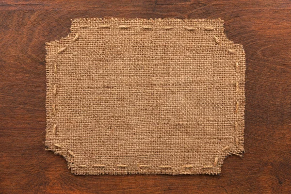 Frame of burlap, lies on a background of wood — Stok Foto