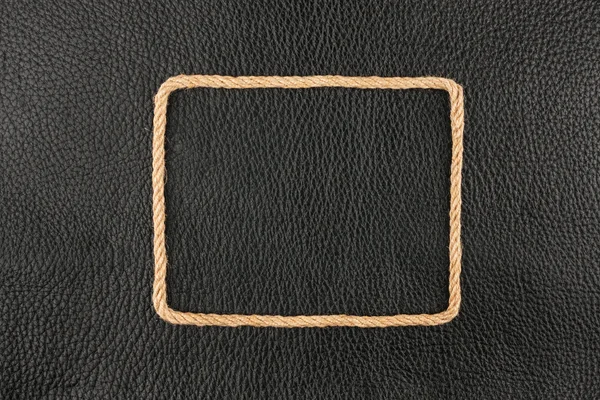 Frame of rope, lies on a background of a black natural leather — Stock Photo, Image