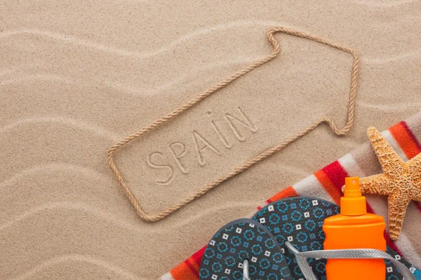 Espanha ponteiro e acessórios de praia deitado na areia — Fotografia de Stock