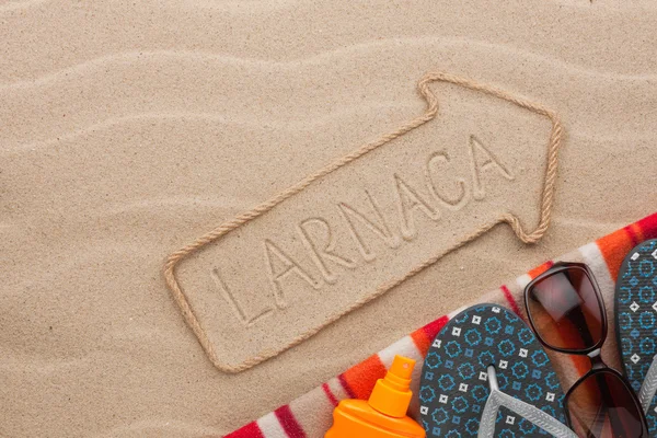 Larnaca  pointer and beach accessories lying on the sand — Stock Photo, Image