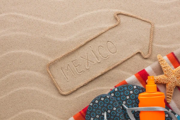 Mexico pointer and beach accessories lying on the sand — Stock Photo, Image