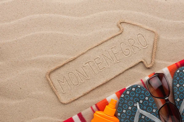 Montenegro  pointer and beach accessories lying on the sand — Stock Photo, Image