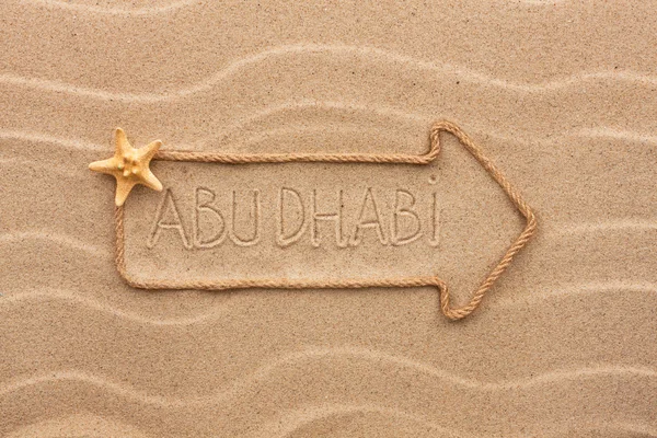 Arrow made of rope and sea shells with the word Abu dhabi on the — Stock Photo, Image