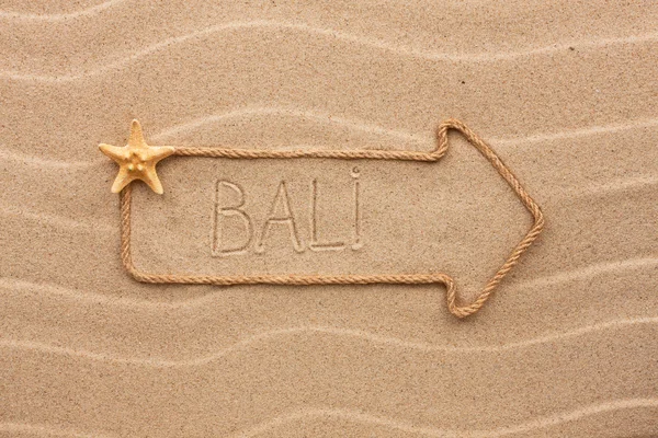 Arrow made of rope and sea shells with the word Bali on the sand — Stock Photo, Image