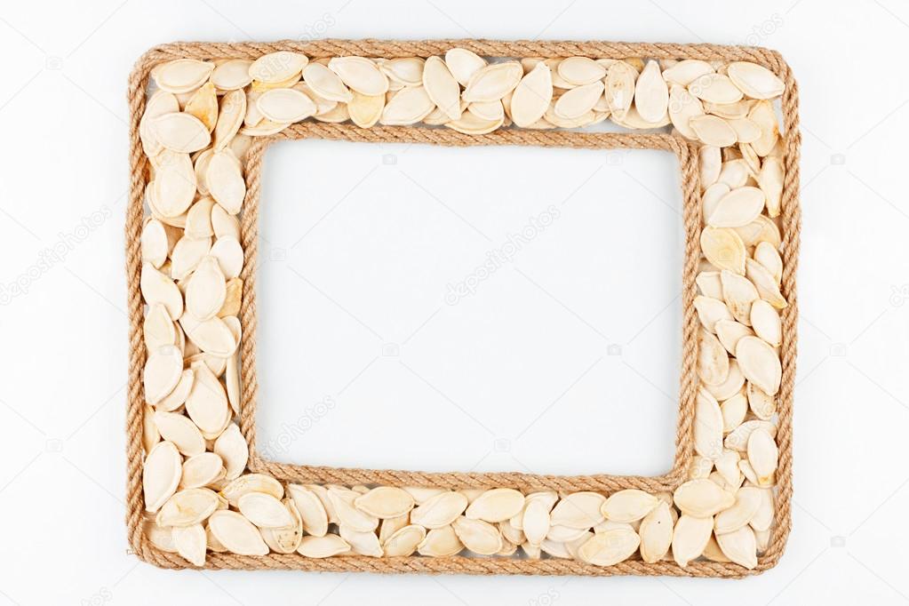 Two frames made of the rope with pumpkin seeds on a white backgr