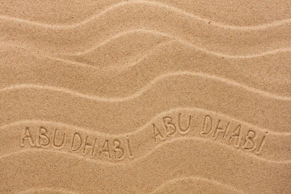 Abu Dhabi  inscription on the wavy sand — Stock Photo, Image