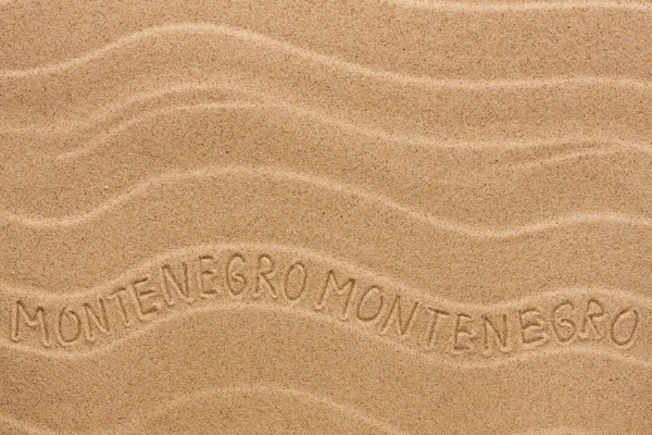 Montenegro inscription on the wavy sand — Stock Photo, Image