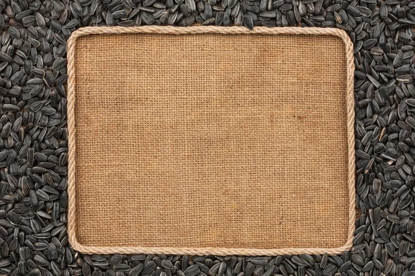 Marco hecho de cuerda con semillas de girasol sobre tela de saco — Foto de Stock