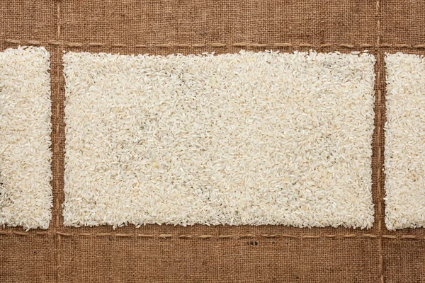 Rice grains on sackcloth, with place for your text — Stock Photo, Image