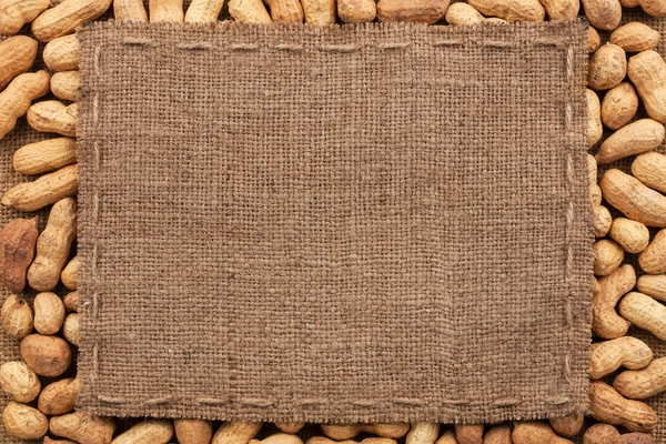 Frame made of burlap with the line lies on peanut — Stock Photo, Image