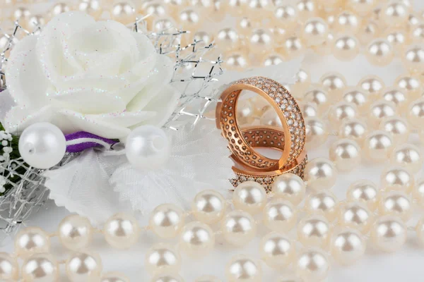 Anneaux de mariage parmi les perles avec fleur — Photo