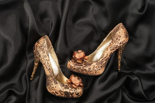 High-heeled shoes  lying on black  fabric — Stock Photo, Image