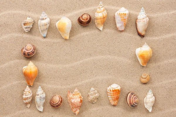 Frame made of seashell on a wavy sand — Stock Photo, Image