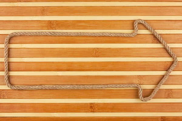 Arrow made of rope  lies on a bamboo mat — Stock Photo, Image