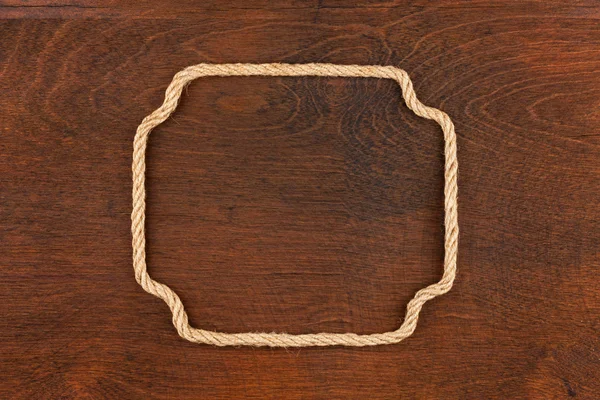 Frame of rope, lies on a background of a wooden surface — Stock Photo, Image