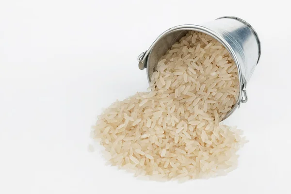 Rice grains spilling out of bucket — Stock Photo, Image