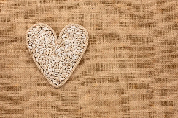 Serce się z liny z nasion słonecznika, leżącego na worze — Zdjęcie stockowe