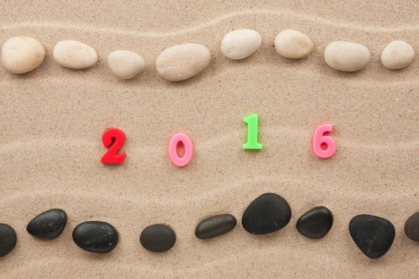 Nový rok 2016 na písku mezi kameny — Stock fotografie