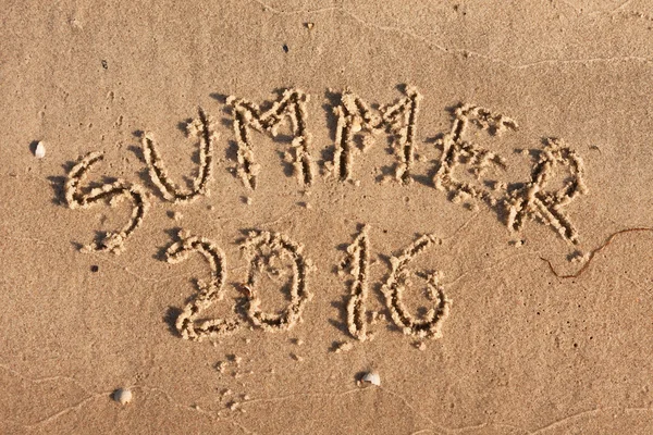 Verão 2016 escrito na areia nos raios do sol — Fotografia de Stock