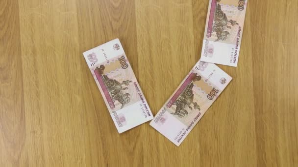 Podnikatel hází rublů na dřevěný stůl, pozadí peníze