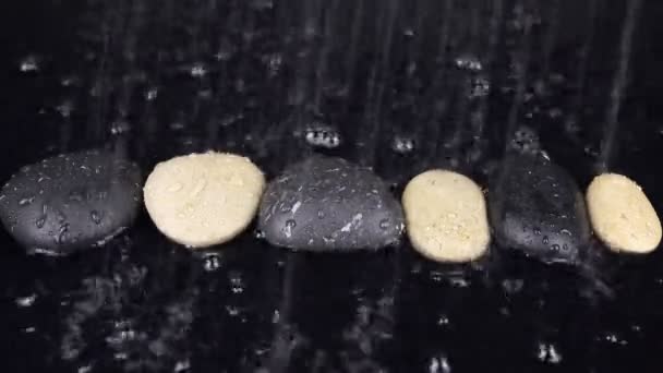 Gotas de chuva caindo sobre as pedras brancas e pretas — Vídeo de Stock