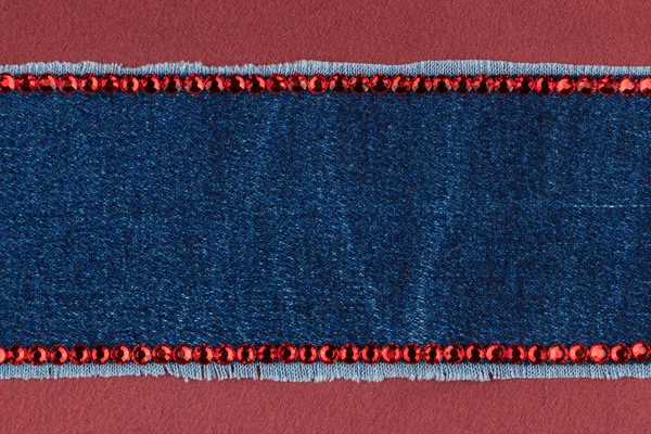 Textura na moda, calça jeans e strass vermelhos em uma seda vermelha — Fotografia de Stock