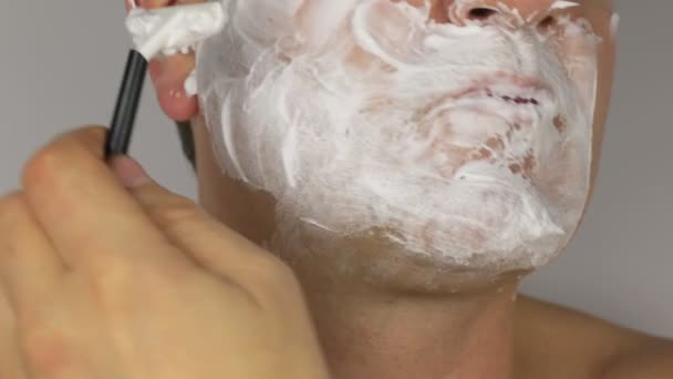 Крупный план бритья человека, бритья бритвой с лезвием — стоковое видео