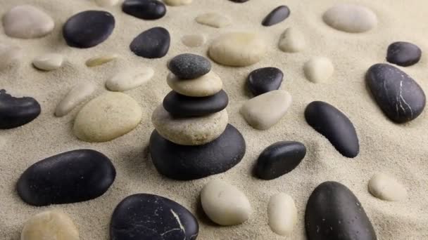 Pyramide de pierres sur sable debout parmi les rochers — Video