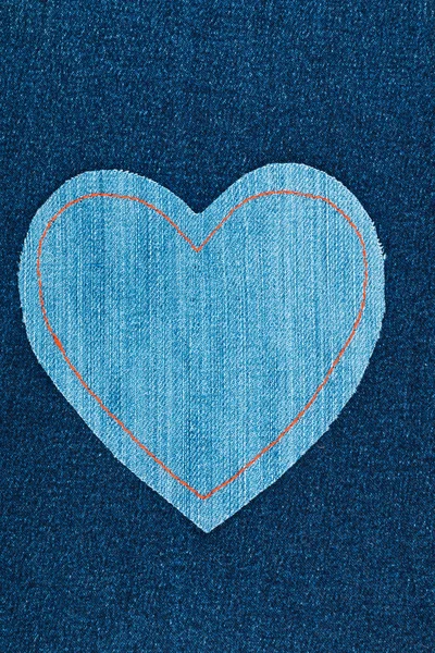 Coeur symbolique fait de jeans couchés sur un jean foncé — Photo