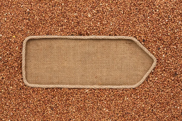 Pointer made from rope with grains buckwheat  lying on sackcloth