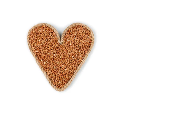 Symbolic heart made from rope with buckwheat grains — Stock Photo, Image
