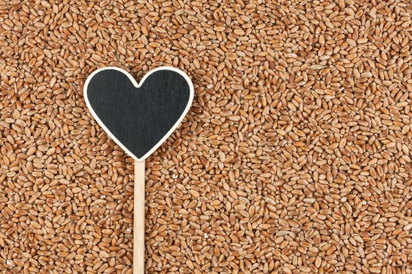 El puntero en forma de corazón se encuentra en los granos de trigo — Foto de Stock