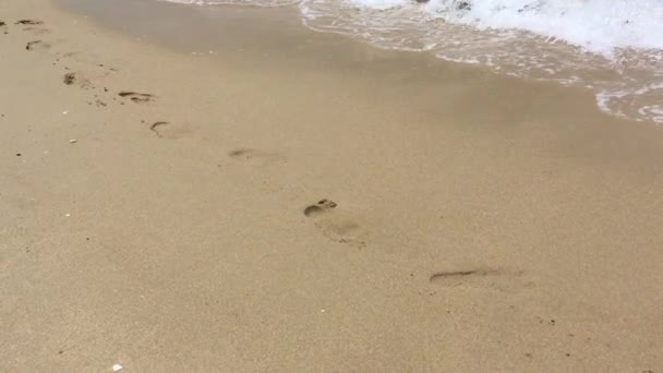 Die Fußabdrücke Sand Wurden Vom Wasser Weggespült — Stockvideo