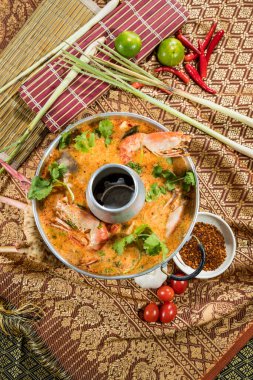 Geleneksel bir Tayland güveç tenceresi baharatlı Tom yum çorbası, karides, otlar ve bacalı metal bir tencerede servis edilen taze malzemeler..