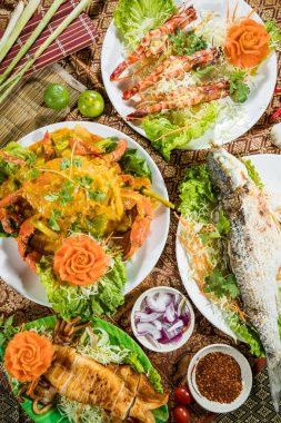 Izgara karides, balık, körili yengeç ve canlı garnitürlü mürekkep balığı içeren renkli bir Tayland deniz ürünü..