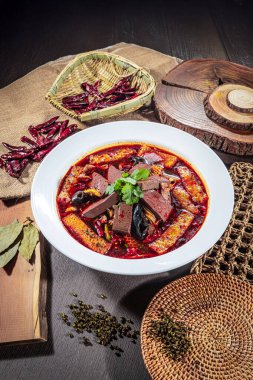 Baharatlı Sichuan usulü işkembe, kan küpleri, mantarlar ve kırmızı biber yağlı, sade süslemeli..