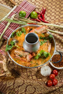 Tayland usulü karides, bitki ve baharatlı Tom Yum çorbası. Geleneksel kumaş ve taze malzemelerle şekillendirilmiş..