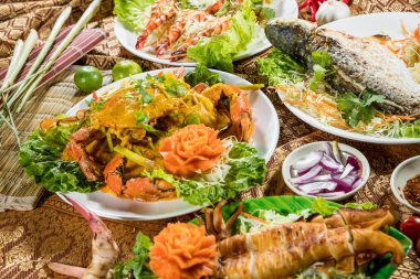 Izgara balık, karides, körili yengeç ve mürekkep balığı ile kaplanmış, sebze ve Tayland usulü garnitürle servis edilen bir gurme deniz ürünleri..