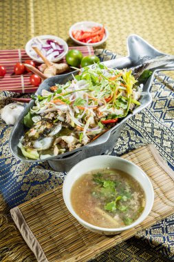 Tayland usulü balık, içinde çorba ve Tayland malzemeleri bulunan sebze ve otlarla servis edilir..