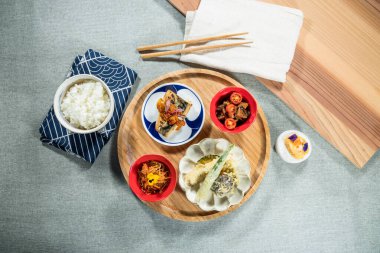 Geleneksel Japon yemeği seti. Pirinç, tempura, erişte, ızgara balık ve tatlı. Sanatsal kaplama ve dengeli renkler sunumu güçlendirir.